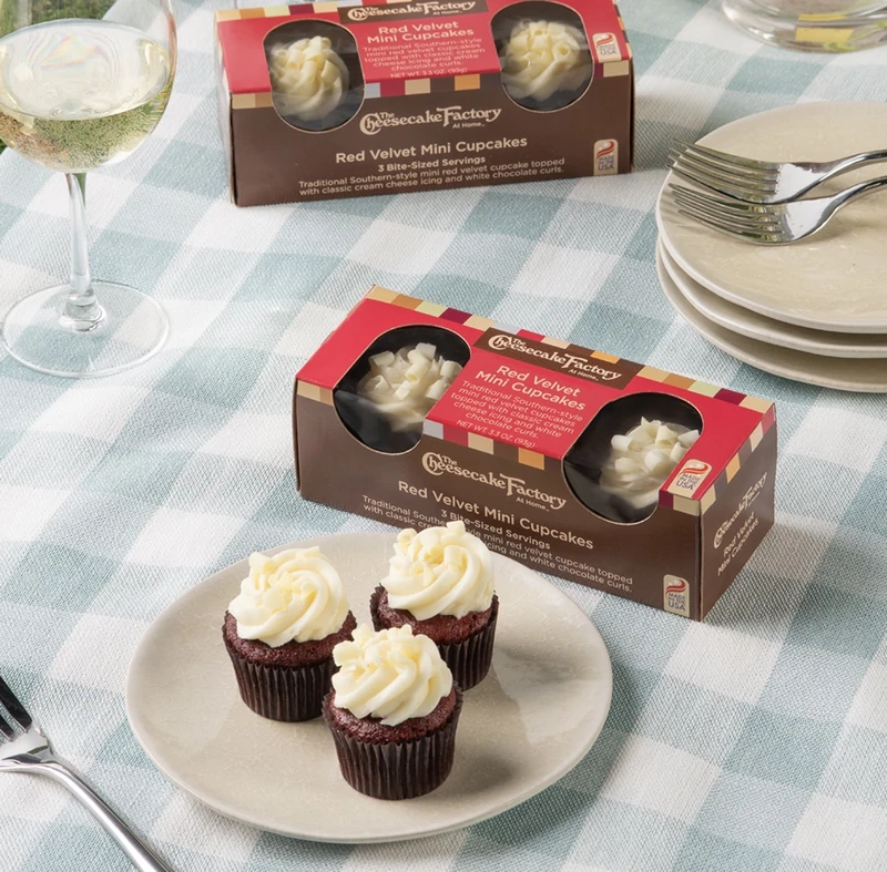 The Cheesecake Factory At Home Red Velvet Mini Cupcake boxes and three cupcakes on a plate